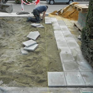 Élagueur 17 réalisant une pose précise de clôture en PVC pour une solution durable.